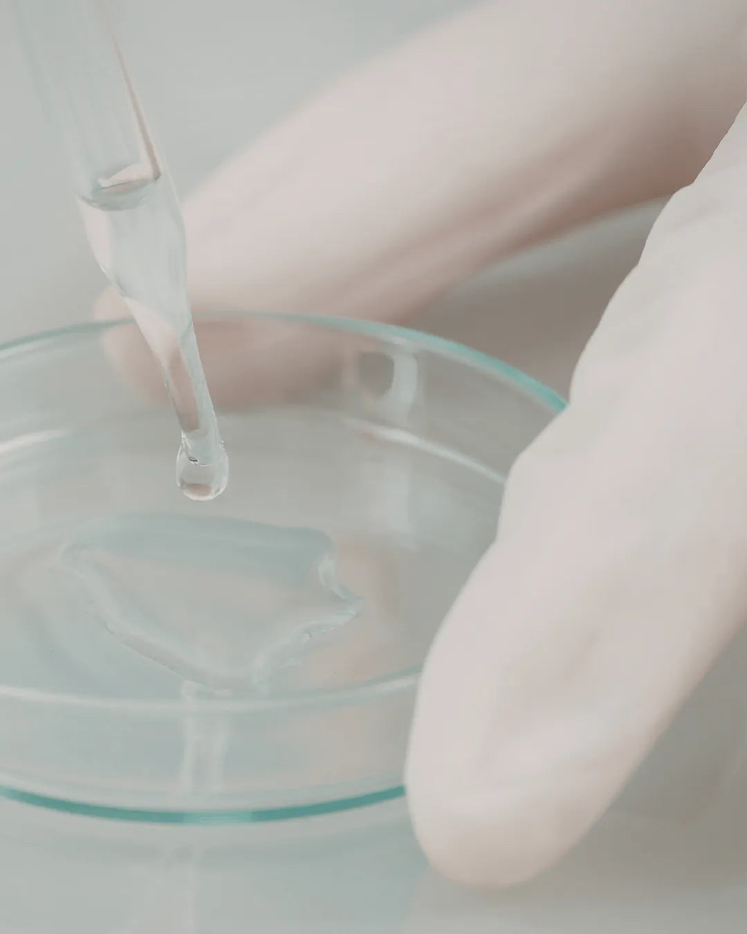 Skincare serum drop from pipette in laboratory setting